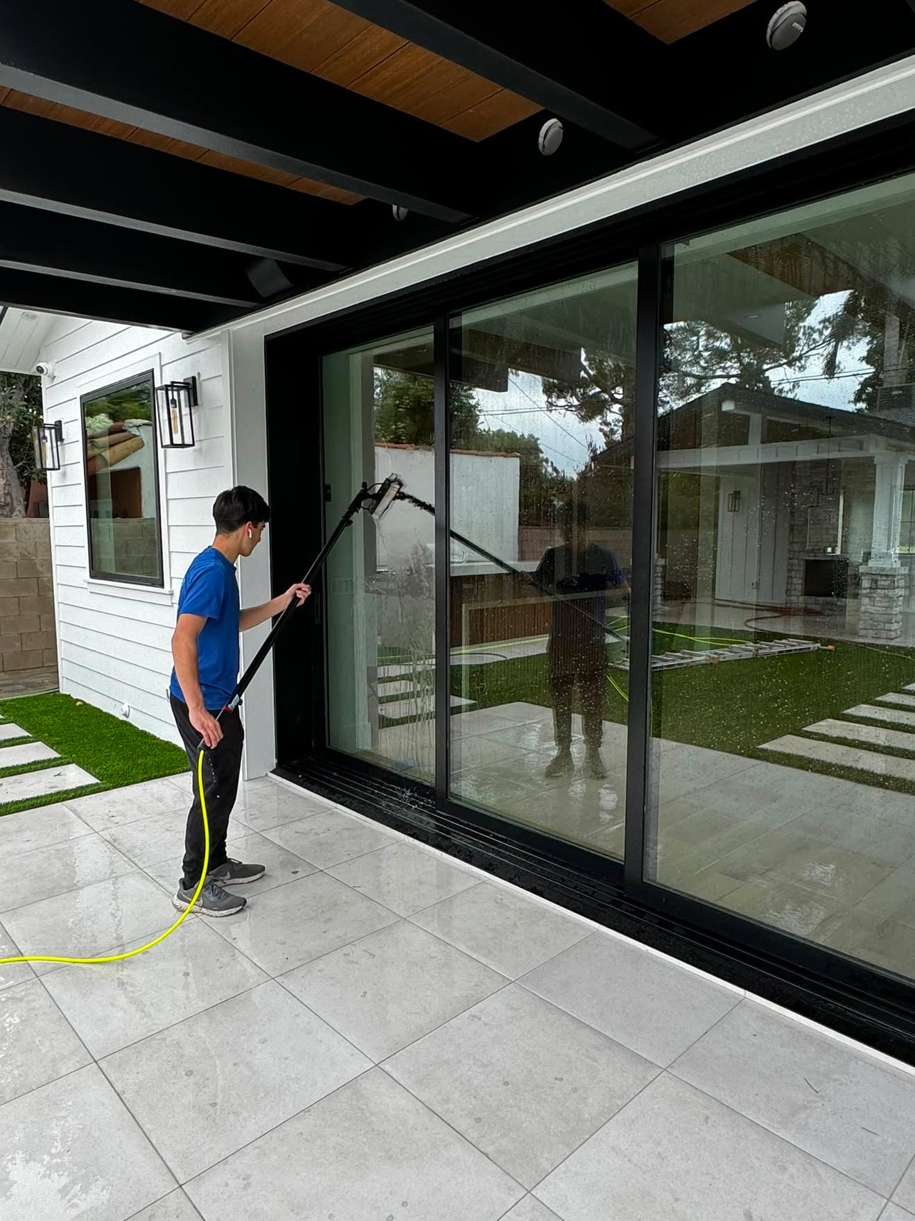 Papa's technician cleaning a wall of patio glass doors