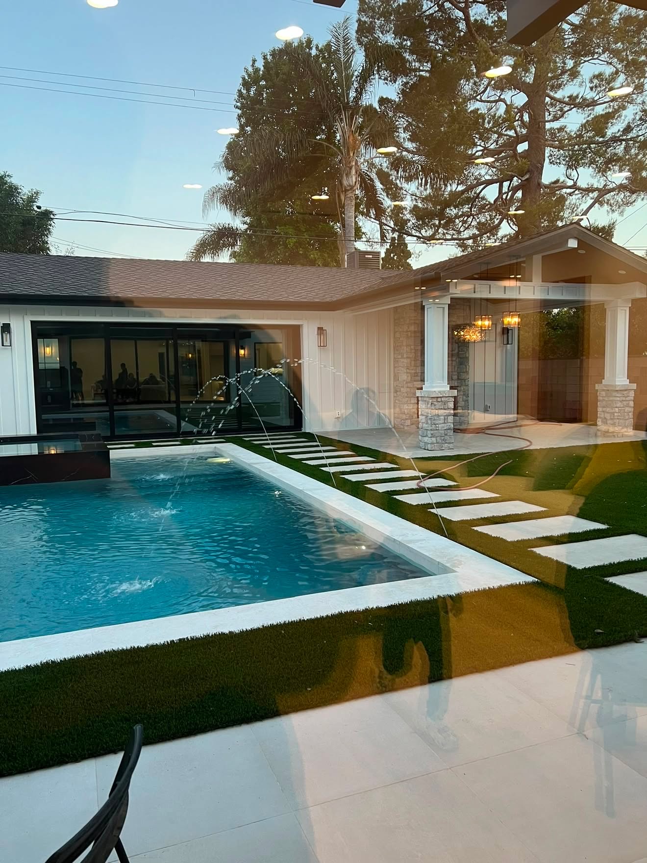 Streak-free glass wall looking out to a pool and patio