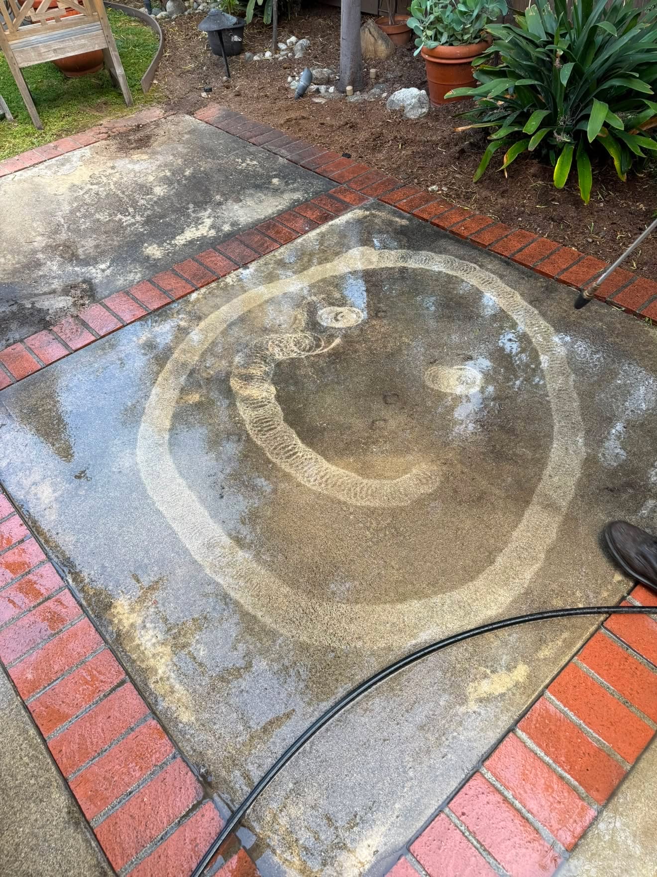 Concrete patio mid pressure wash showing clean versus dirty
