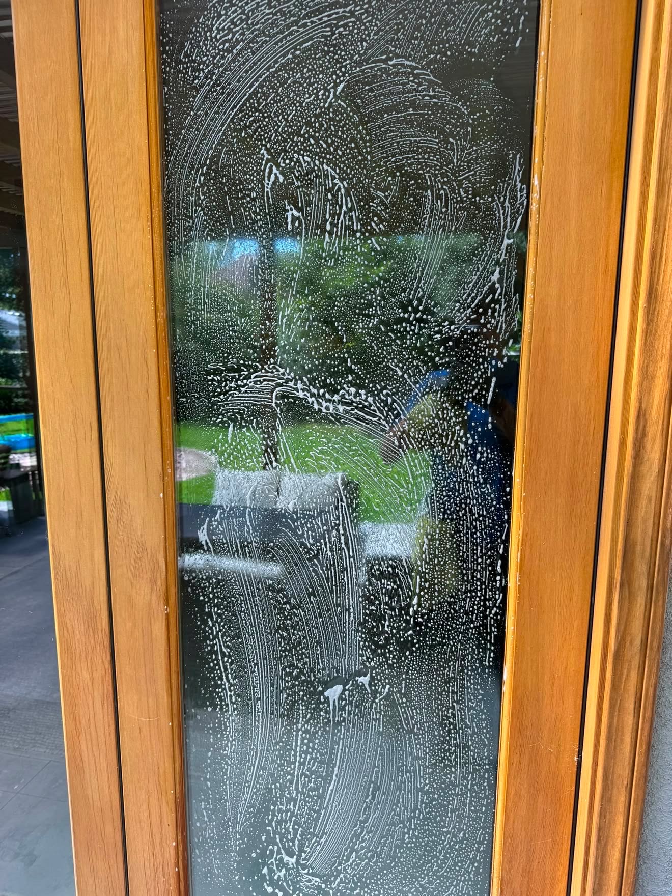 Soapy glass door mid-clean during a window washing service