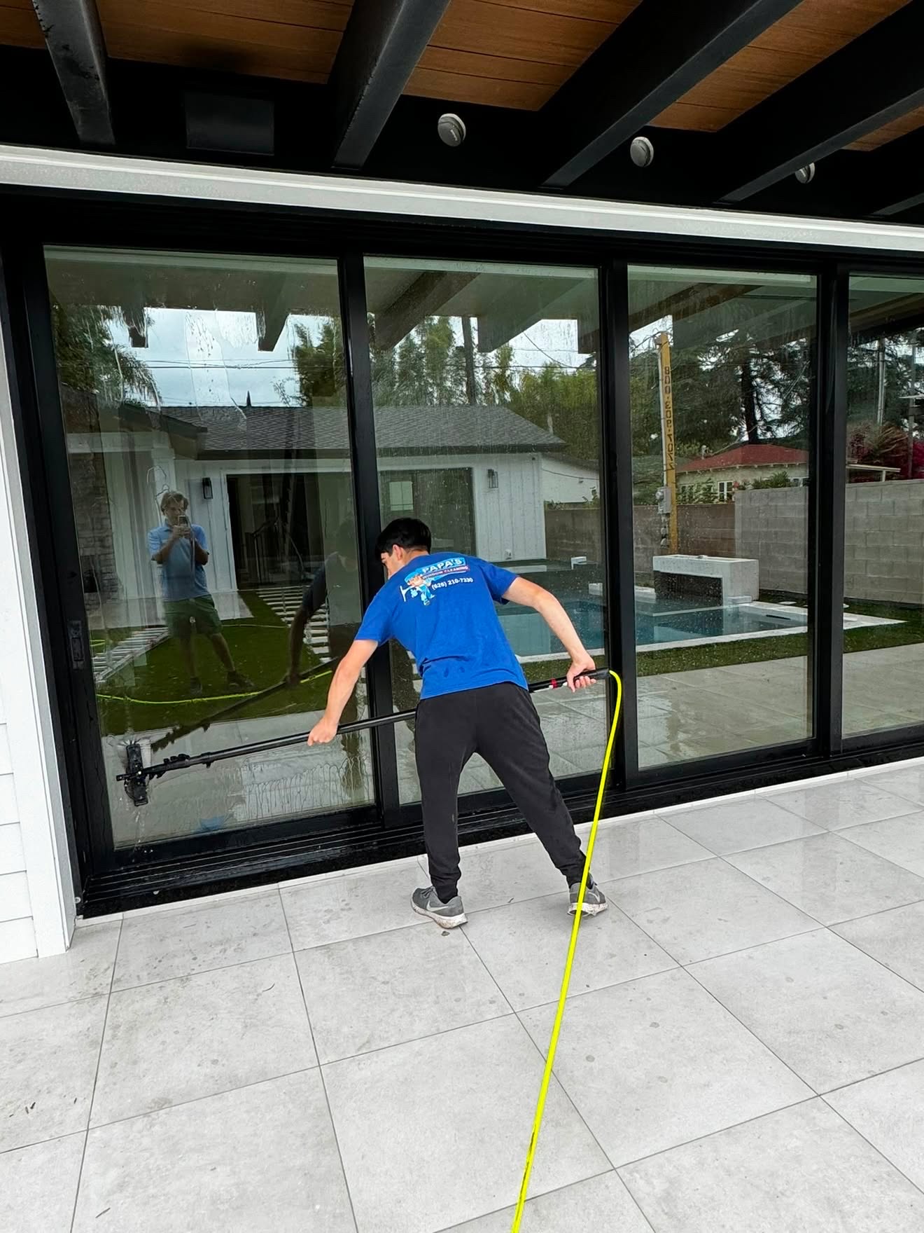 Papa's technician washing large sliding glass doors